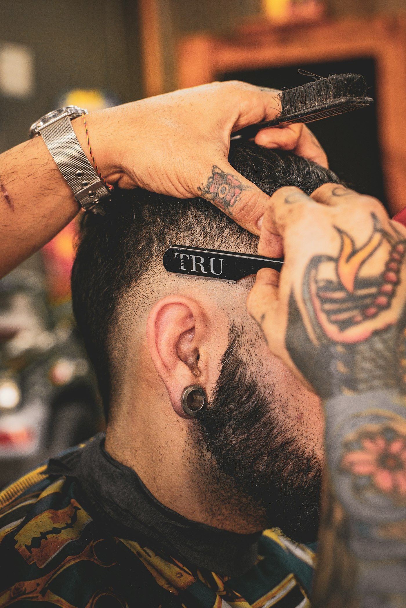 A student-barber concentrating on a clean fade